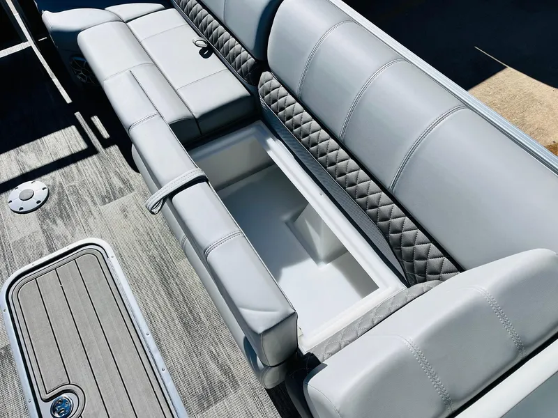 Slide: The Image of 2025 Ranger Reata 223C boat interior with gray cushioned seating and storage compartment. - 19