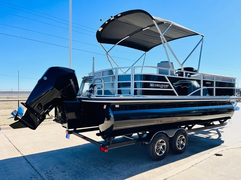 Slide: The Image of 2025 Ranger Reata 223C pontoon boat on trailer, featuring sleek black design and canopy. - 5