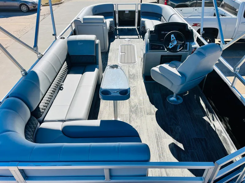 Slide: The Image of 2025 Ranger Reata 223C pontoon boat interior with plush seating and modern helm. - 9