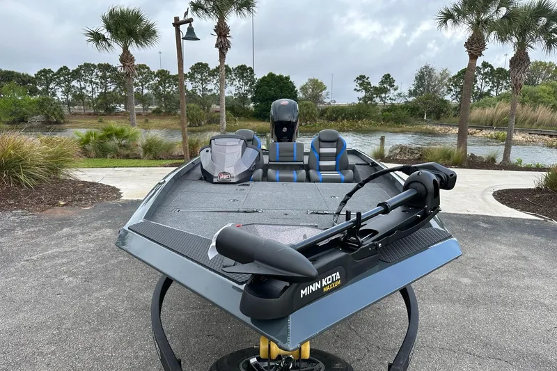 Slide: The Image of 2025 Ranger RT188P boat with Minn Kota motor, parked near a scenic lake. - 2