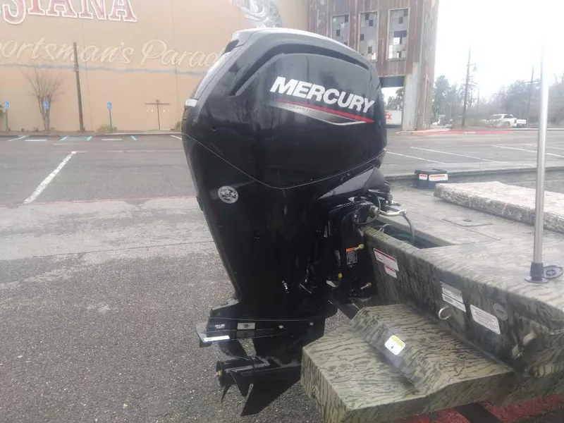 Slide: The Image of 2025 Tracker Grizzly 1860 CC with Mercury outboard motor in parking lot. - 2
