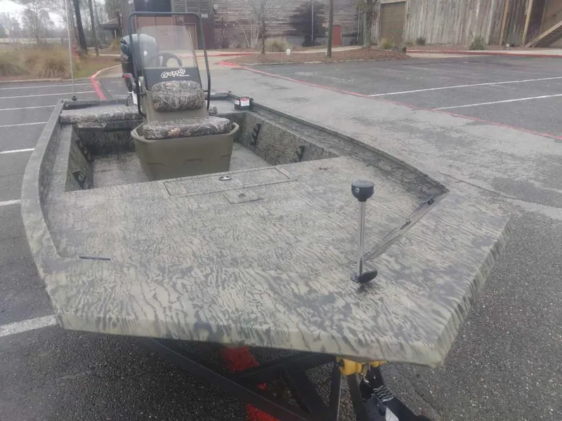 Slide: The Image of 2025 Tracker Grizzly 1860 CC boat with camouflage design in a parking lot. - 7