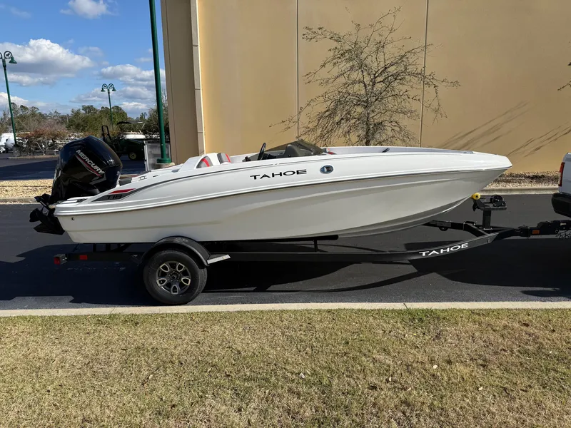 Slide: The Image of 2025 Tahoe T18 boat on trailer, parked outdoors, side view. - 1