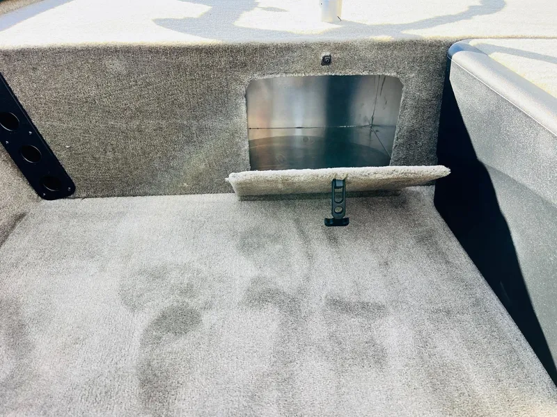 Slide: The Image of 2025 Tracker Bass Tracker Classic Limited interior storage compartment with carpeted finish. - 15