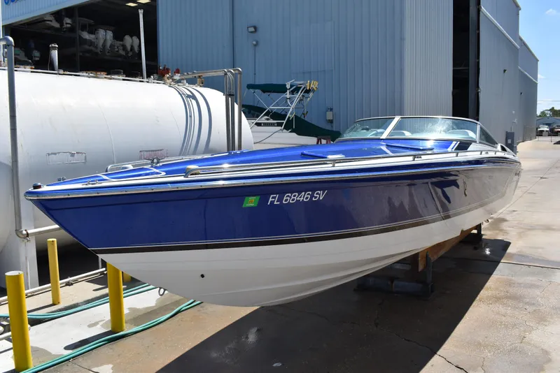 Slide: The Image of 2008 Formula 353 FASTech boat in blue and white, docked near a warehouse. - 1