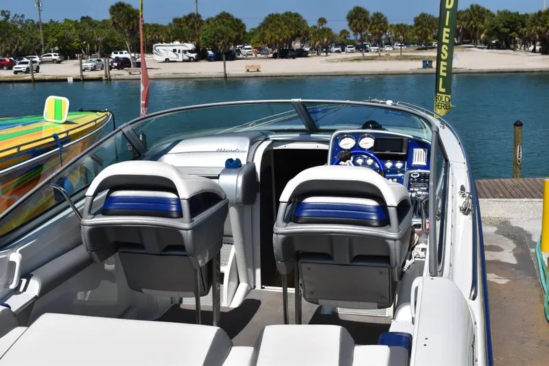 Slide: The Image of 2008 Formula 353 FASTech boat interior with dual seats and dashboard, docked by a scenic waterfront. - 15