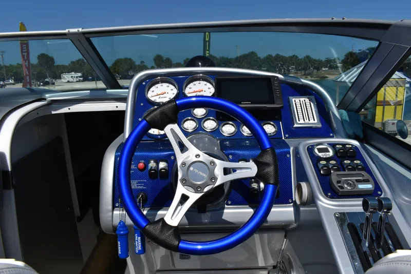 Slide: The Image of 2008 Formula 353 FASTech boat dashboard with blue steering wheel and gauges. - 23