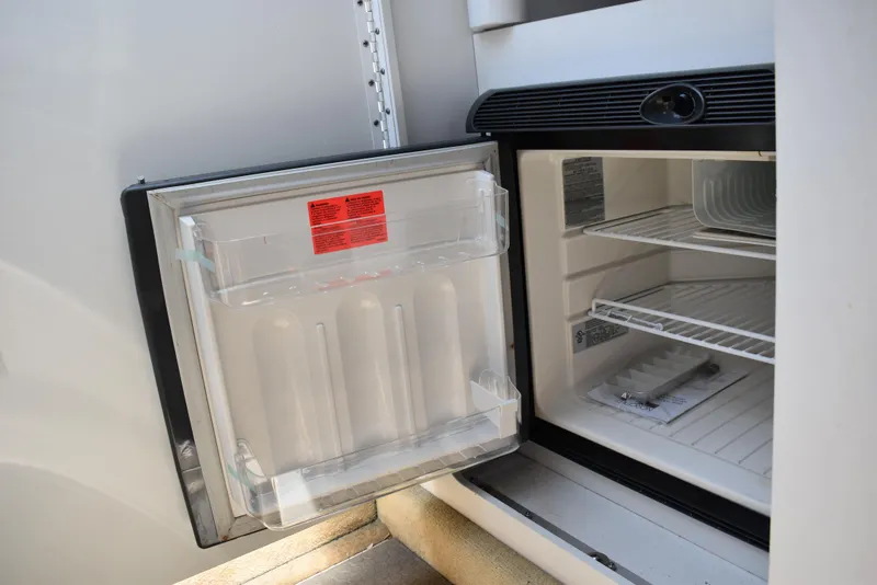Slide: The Image of Open refrigerator in 2008 Formula 353 FASTech boat, showing empty shelves and door storage. - 32