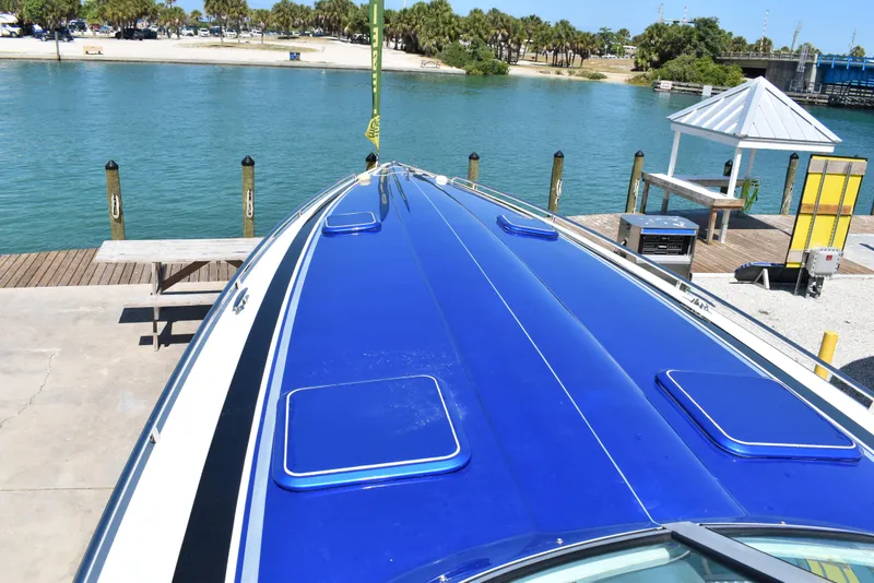 Slide: The Image of 2008 Formula 353 FASTech boat with blue deck, docked by a scenic waterfront. - 39