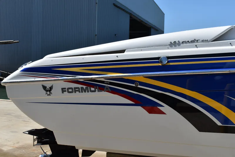 Slide: The Image of 2008 Formula 353 FASTech boat with colorful graphics, docked near a warehouse. - 7