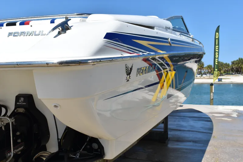 Slide: The Image of 2008 Formula 353 FASTech boat with vibrant graphics docked by the water. - 8