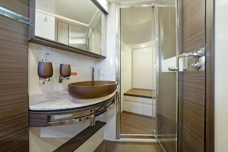 Slide: The Image of Luxurious bathroom in 2017 Azimut 60 Flybridge yacht with modern fixtures and wood accents. - 24