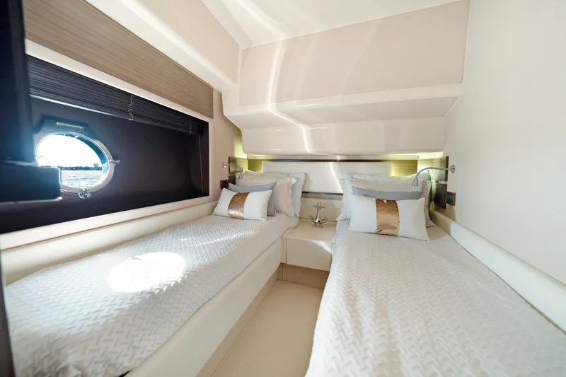 Slide: The Image of Luxurious twin cabin interior of 2017 Azimut 60 Flybridge yacht, featuring elegant bedding and porthole. - 29