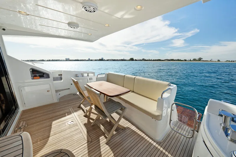 Slide: The Image of 2017 Azimut 60 Flybridge yacht deck with seating, overlooking serene blue waters. - 4
