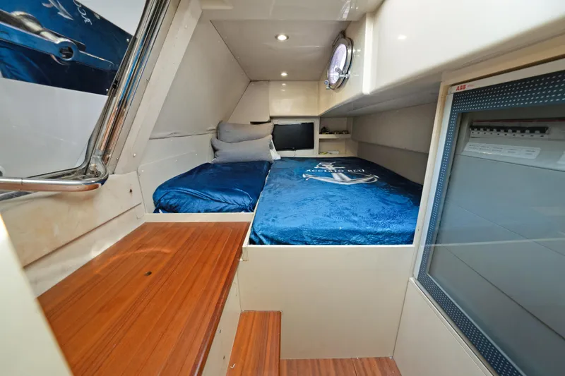 Slide: The Image of 2017 Azimut 60 Flybridge cabin with blue bedding and wooden accents. - 45