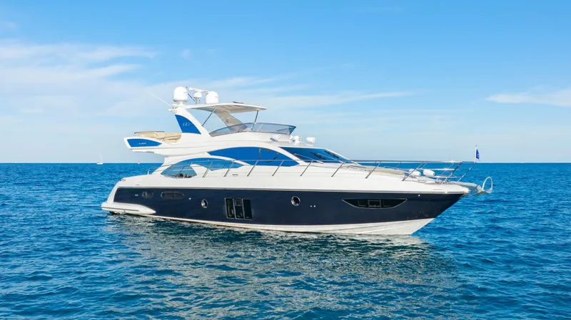 Slide: The Image of 2017 Azimut 60 Flybridge yacht cruising on open sea under clear blue sky. - 47