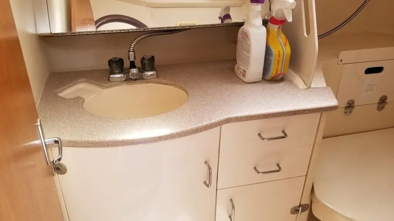 Slide: The Image of 1999 Hunter 340 bathroom sink with countertop and cleaning supplies. - 12