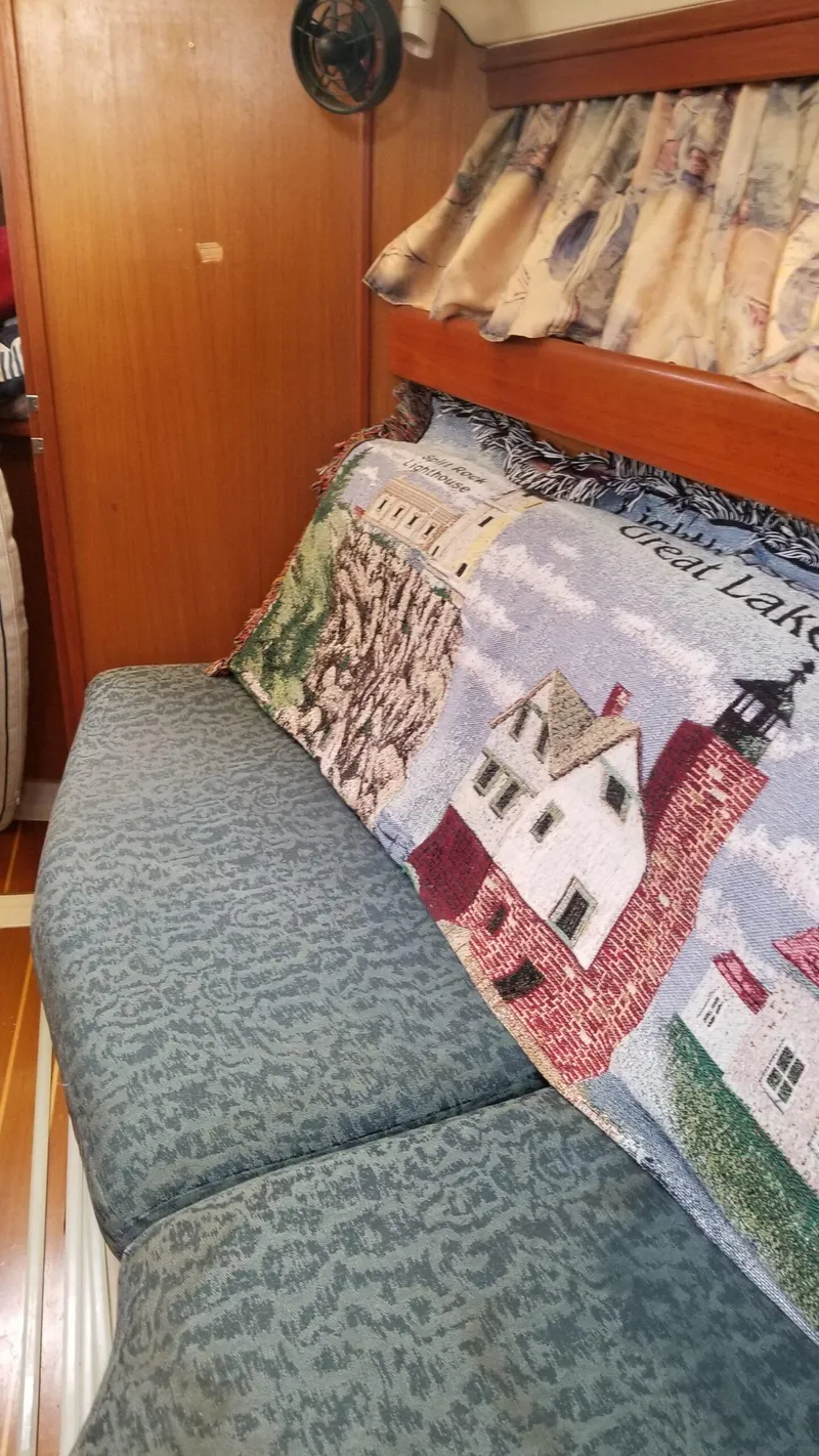 Slide: The Image of Interior of a 1999 Hunter 340 sailboat with patterned cushions and decorative throw. - 16