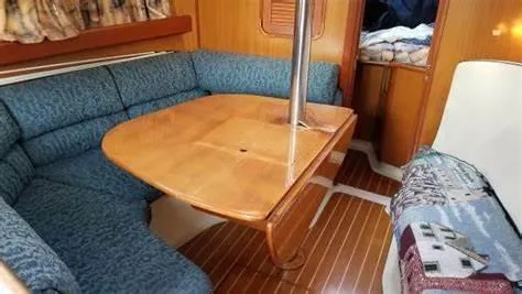 Slide: The Image of Interior of a 1999 Hunter 340 sailboat with wooden table and blue seating. - 18