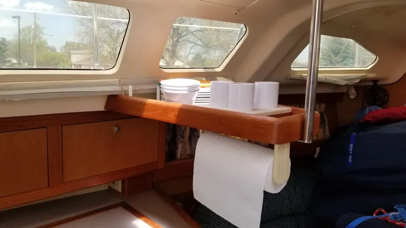 Slide: The Image of Interior of a 1999 Hunter 340 sailboat with wooden cabinetry and dining setup. - 19