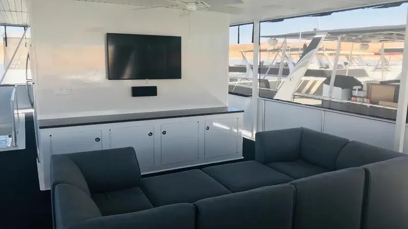 Slide: The Image of Luxurious yacht interior with gray sofa, wall-mounted TV, and marina view. Adonia Inspiration Trip #14, 2019. - 17