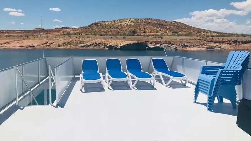 Slide: The Image of Deck of Adonia Inspiration Trip #14, 2019, with blue lounge chairs and scenic water view. - 22