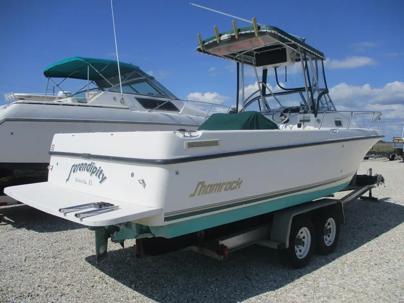 The Image of 2001 Shamrock 246 Walkaround boat on trailer, parked outdoors under blue sky. - 0