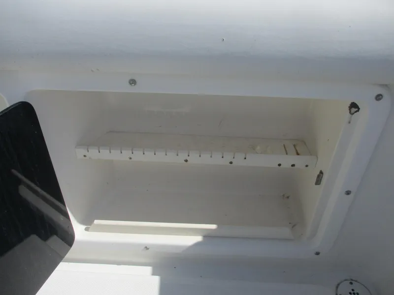 Slide: The Image of Storage compartment on a 2001 Shamrock 246 Walkaround boat, featuring a white interior. - 13