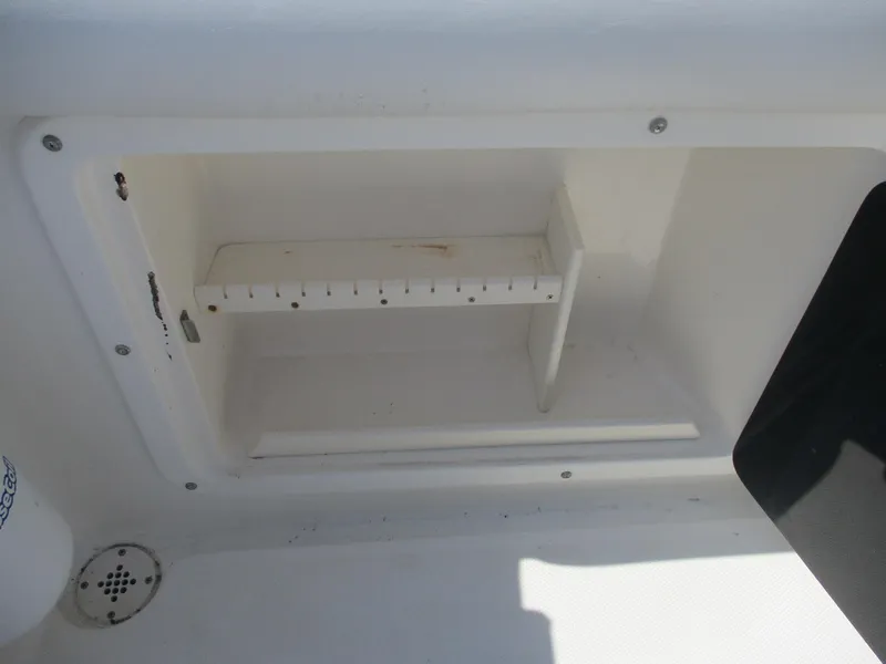 Slide: The Image of Storage compartment on a 2001 Shamrock 246 Walkaround boat, featuring a white interior. - 14