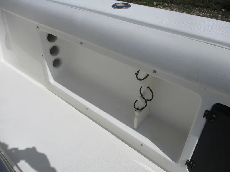 Slide: The Image of 2001 Shamrock 246 Walkaround boat storage compartment with rod holders. - 16