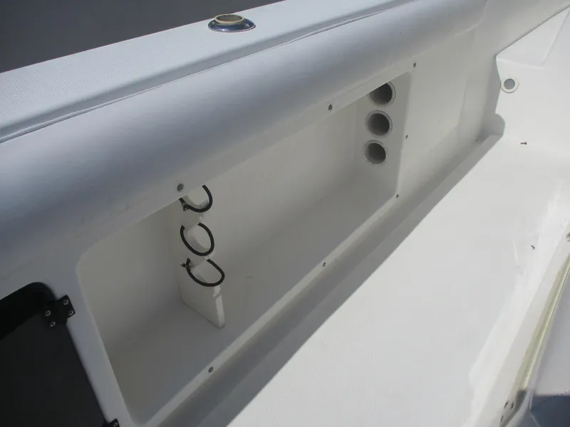 Slide: The Image of 2001 Shamrock 246 Walkaround boat interior storage compartment with rod holders. - 17