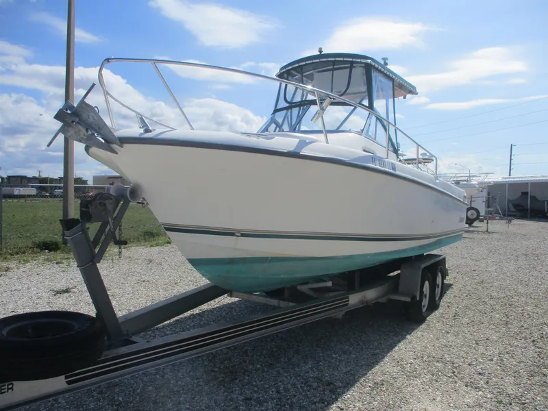 Slide: The Image of 2001 Shamrock 246 Walkaround boat on trailer, parked outdoors under a blue sky. - 2