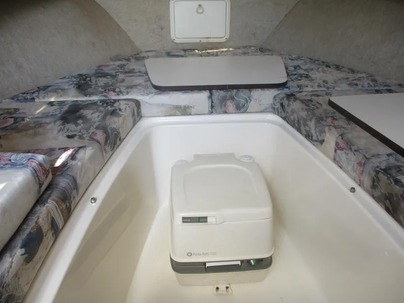 Slide: The Image of 2001 Shamrock 246 Walkaround cabin interior with portable toilet and patterned seating. - 30
