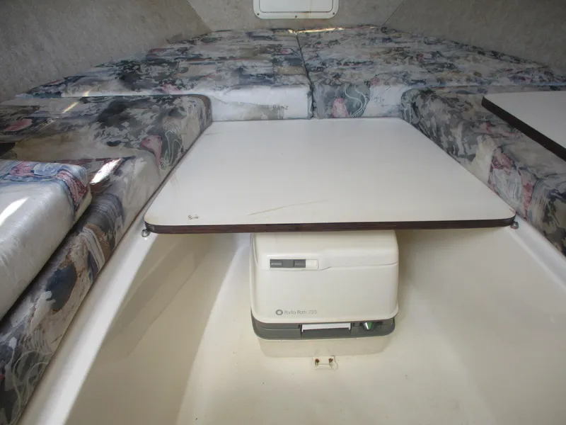 Slide: The Image of 2001 Shamrock 246 Walkaround cabin interior with seating and portable toilet. - 31