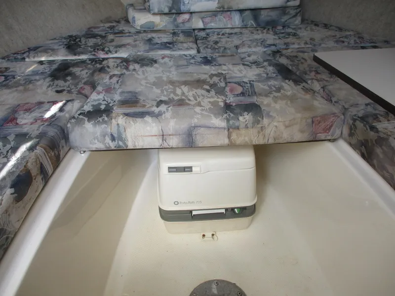 Slide: The Image of 2001 Shamrock 246 Walkaround cabin interior with patterned cushions and portable toilet. - 32