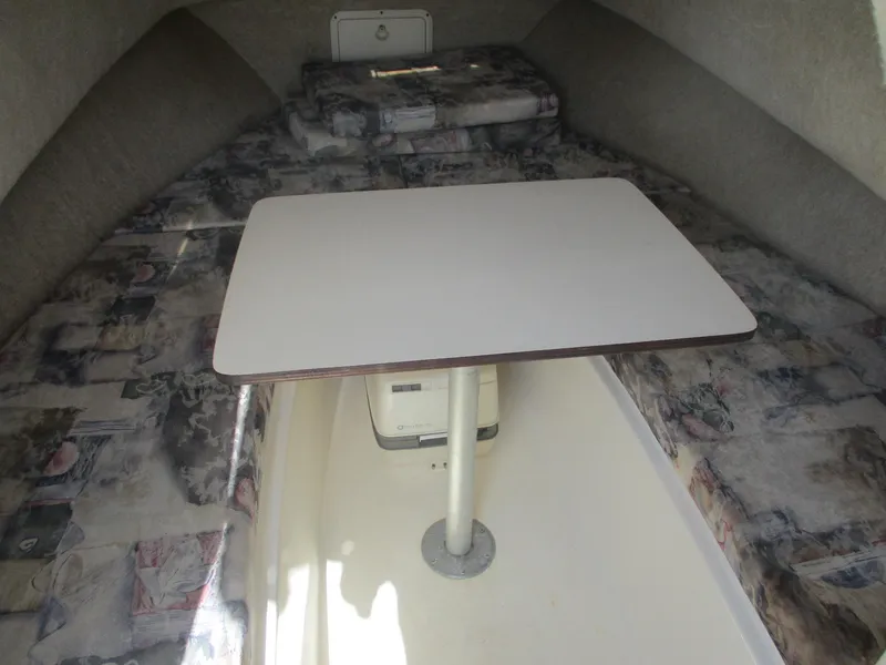 Slide: The Image of 2001 Shamrock 246 Walkaround cabin interior with table and cushioned seating. - 33