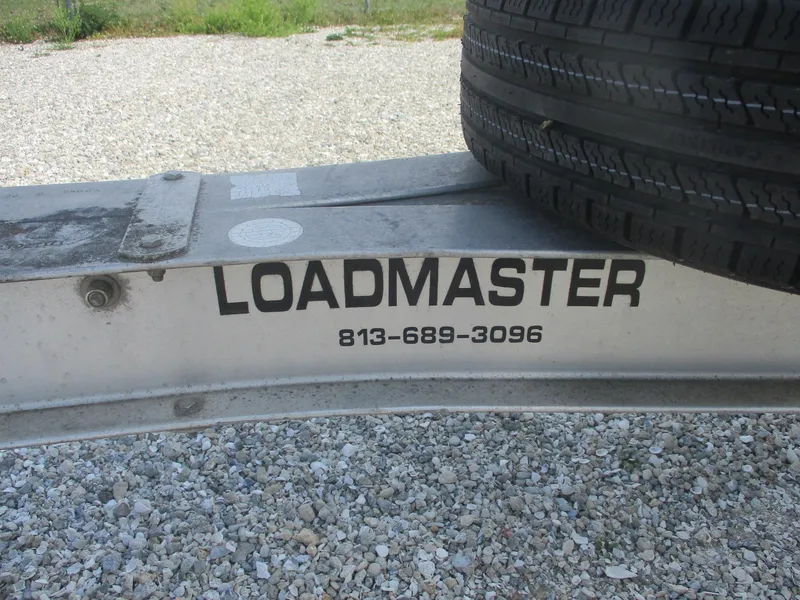 Slide: The Image of Trailer with Loadmaster branding and contact number, supporting a Shamrock 246 Walkaround boat. - 38