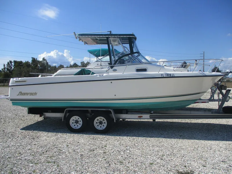 Slide: The Image of 2001 Shamrock 246 Walkaround boat on trailer, parked outdoors under clear sky. - 4