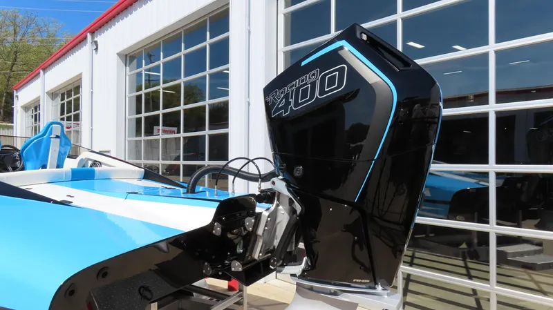 Slide: The Image of 2025 Wright Performance P280 boat with a powerful outboard motor, parked outside a garage. - 3
