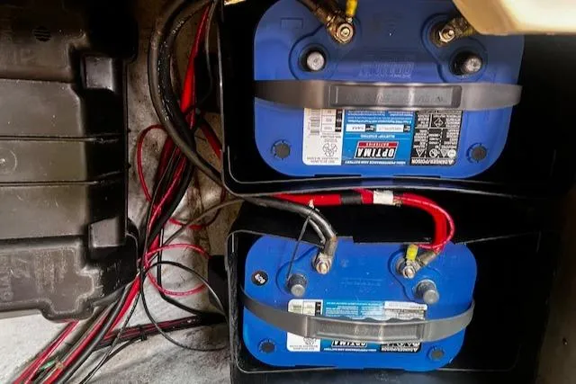 Slide: The Image of Dual marine batteries in a 1988 CAL Sloop, connected with red and black cables. - 13