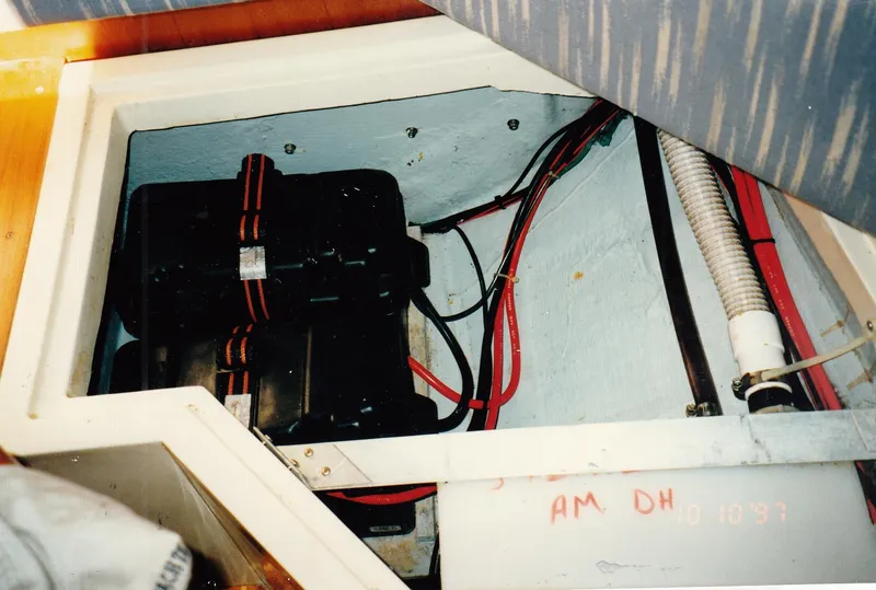 Slide: The Image of 1988 CAL Sloop interior showing battery compartment with wiring and ventilation. - 18