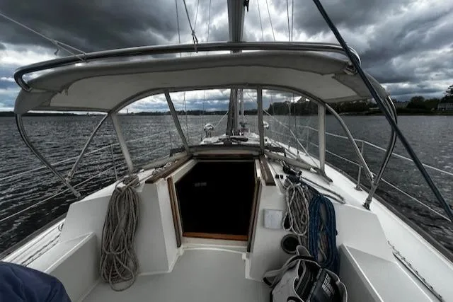 Slide: The Image of 1988 CAL Sloop sailboat on water under cloudy skies. - 24