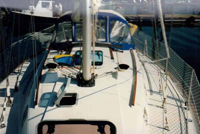 Slide: The Image of 1988 CAL Sloop sailboat deck with rigging and blue canopy in marina. - 25