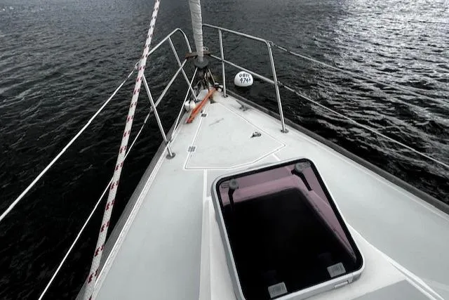 Slide: The Image of 1988 CAL Sloop sailboat deck with hatch, sailing on calm waters. - 28