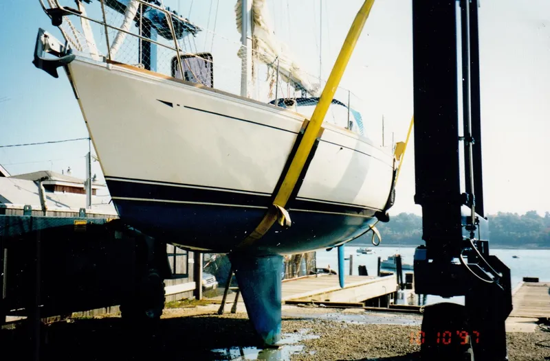 Slide: The Image of 1988 CAL Sloop sailboat being lifted at a marina dock. - 29
