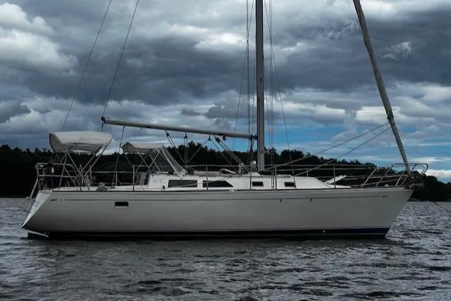 Slide: The Image of 1988 CAL Sloop sailboat on calm water under cloudy sky. - 31