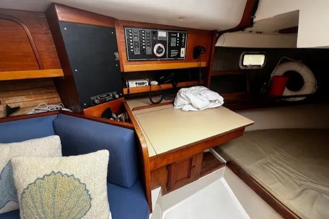 Slide: The Image of 1988 CAL Sloop interior with navigation panel, seating, and cozy cabin space. - 5