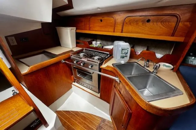 Slide: The Image of 1988 CAL Sloop kitchen with wooden cabinetry, stove, and dual sink. - 6