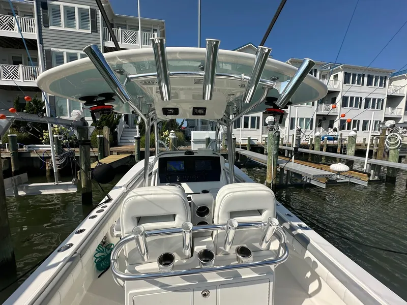 Slide: The Image of 2019 Regulator 28 boat docked, featuring a sleek console and rod holders. - 10