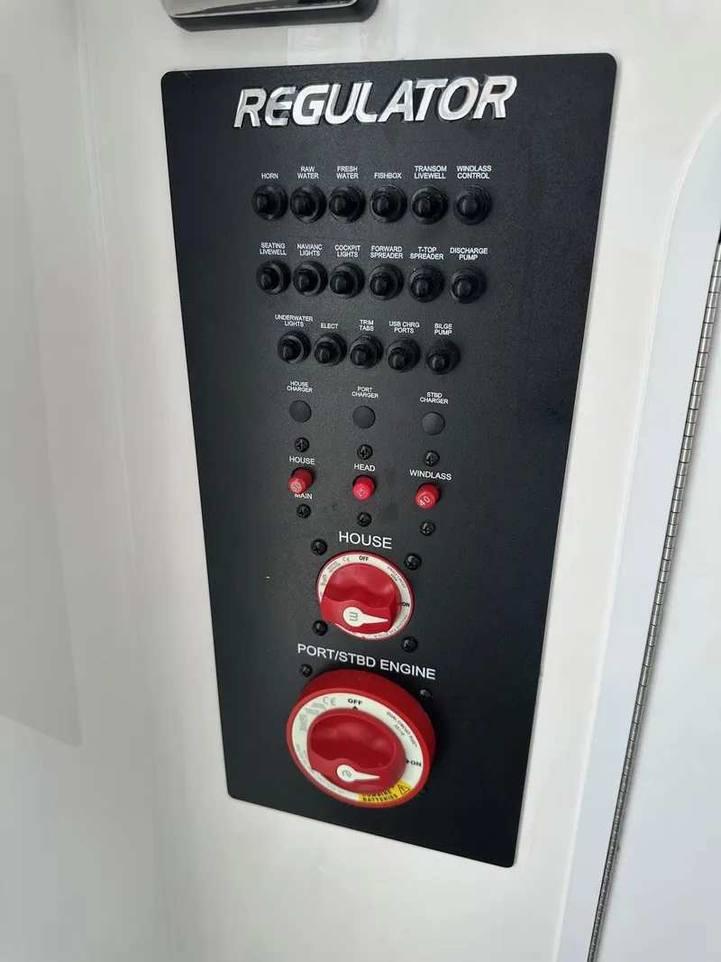 Slide: The Image of Control panel of a 2019 Regulator 28 boat with various switches and dials. - 12